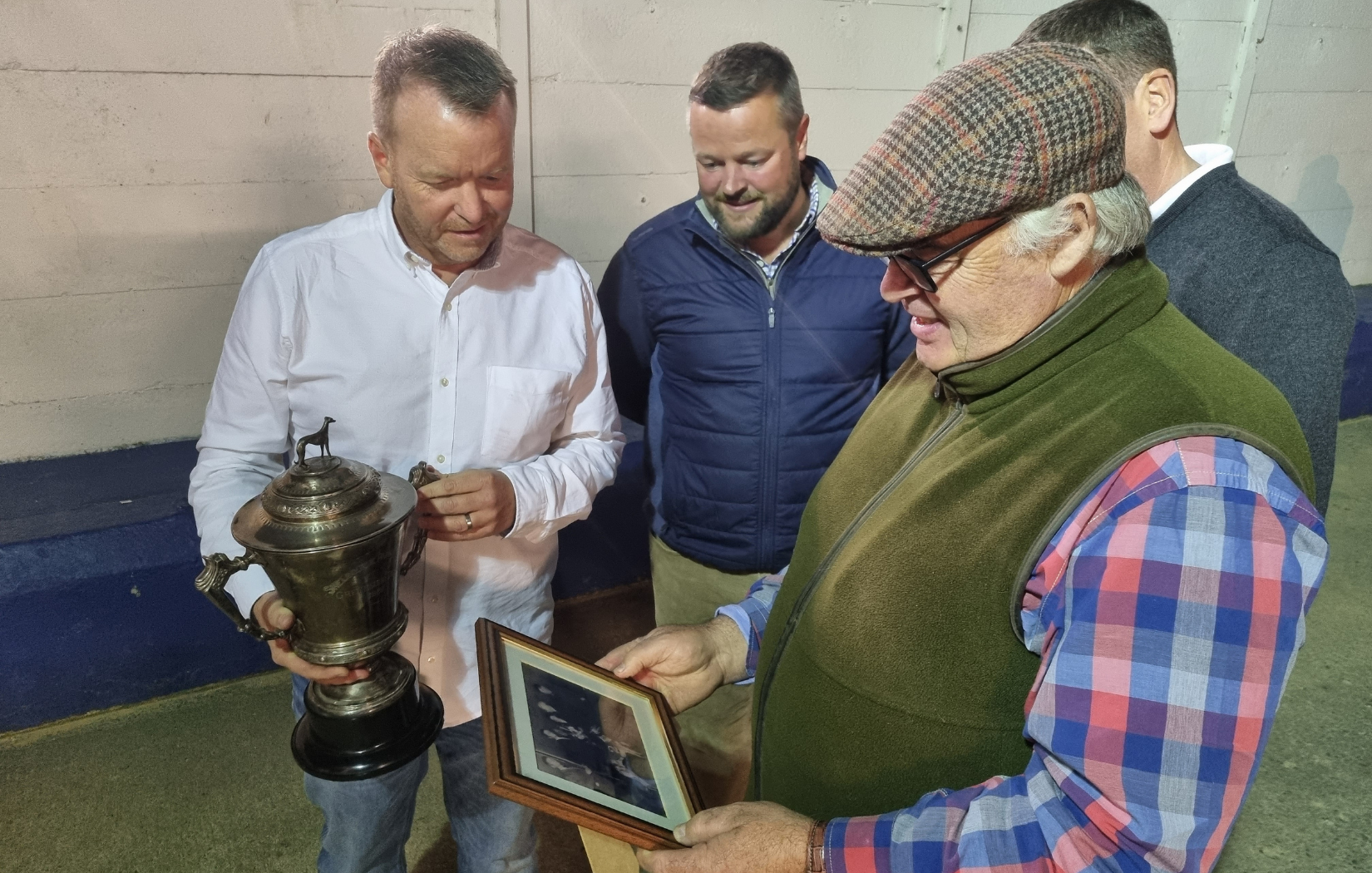 The 1951 Irish greyhound Derby trophy is admired in the kennel area, as another man who knows what it means to win a Derby, Michael Gleeson , takes a look at the presentation photo