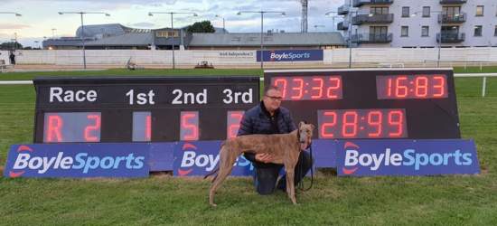 Picture shows Owen McKenna, trainer, pictured with his greyhound Pestana in front of the time clock in Shelbourne Park Greyhound Stadium showing a time of 28.99 as Pestana became the first greyhound to break 29 seconds over the 500 yards distance during the 2020 Irish Greyhound Derby