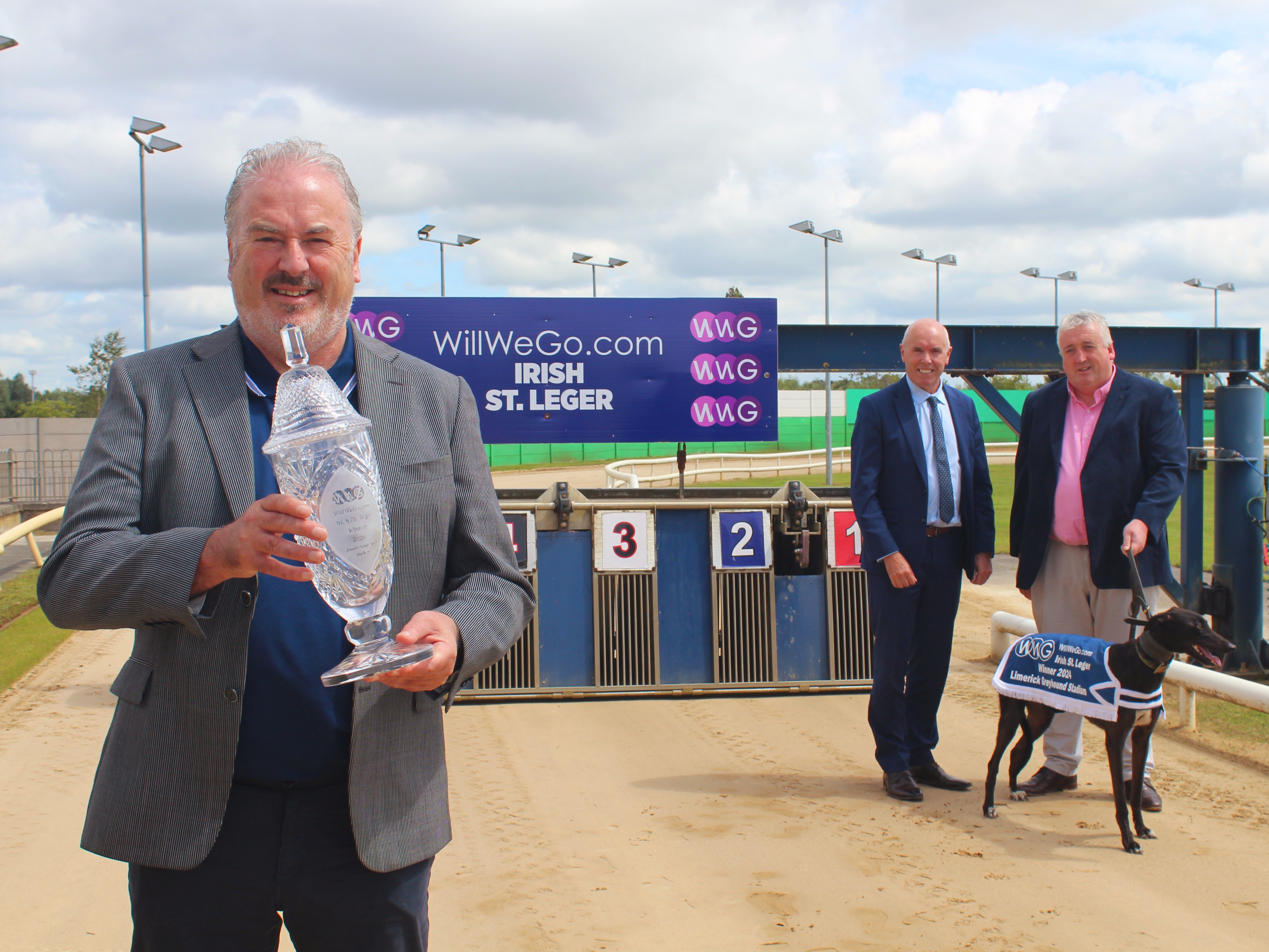 Ray Quinn, representing the sponsor, holding the trophy for this year’s WillWeGo.com Irish St. Leger at Limerick Greyhound Stadium with Tim Lucey, CEO of Greyhound Racing Ireland, and Jody Thompson, Racing Manager, with Sombra the greyhound. Ray Quinn, representing the sponsor, holding the trophy for this year’s WillWeGo.com Irish St. Leger at Limerick Greyhound Stadium with Tim Lucey, CEO of Greyhound Racing Ireland, and Jody Thompson, Racing Manager, with Sombra the greyhound.